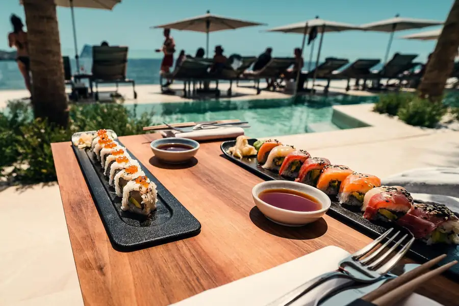 Dos platos de la carta de un restaurante servidos en una terraza junto al mar.