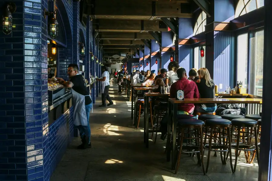 Restaurante lleno en pleno servicio, con el equipo de sala trabajando entre las mesas.
